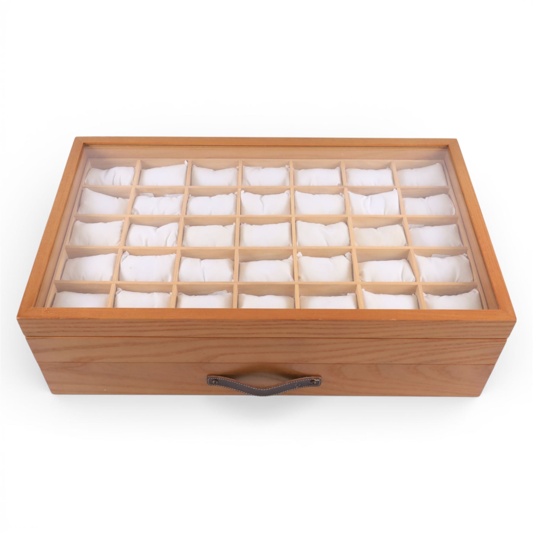 Large wooden watch display case, with glazed lid and spaces for thirty five watches, with drawer beneath containing a collection of leather, metal and other watch straps