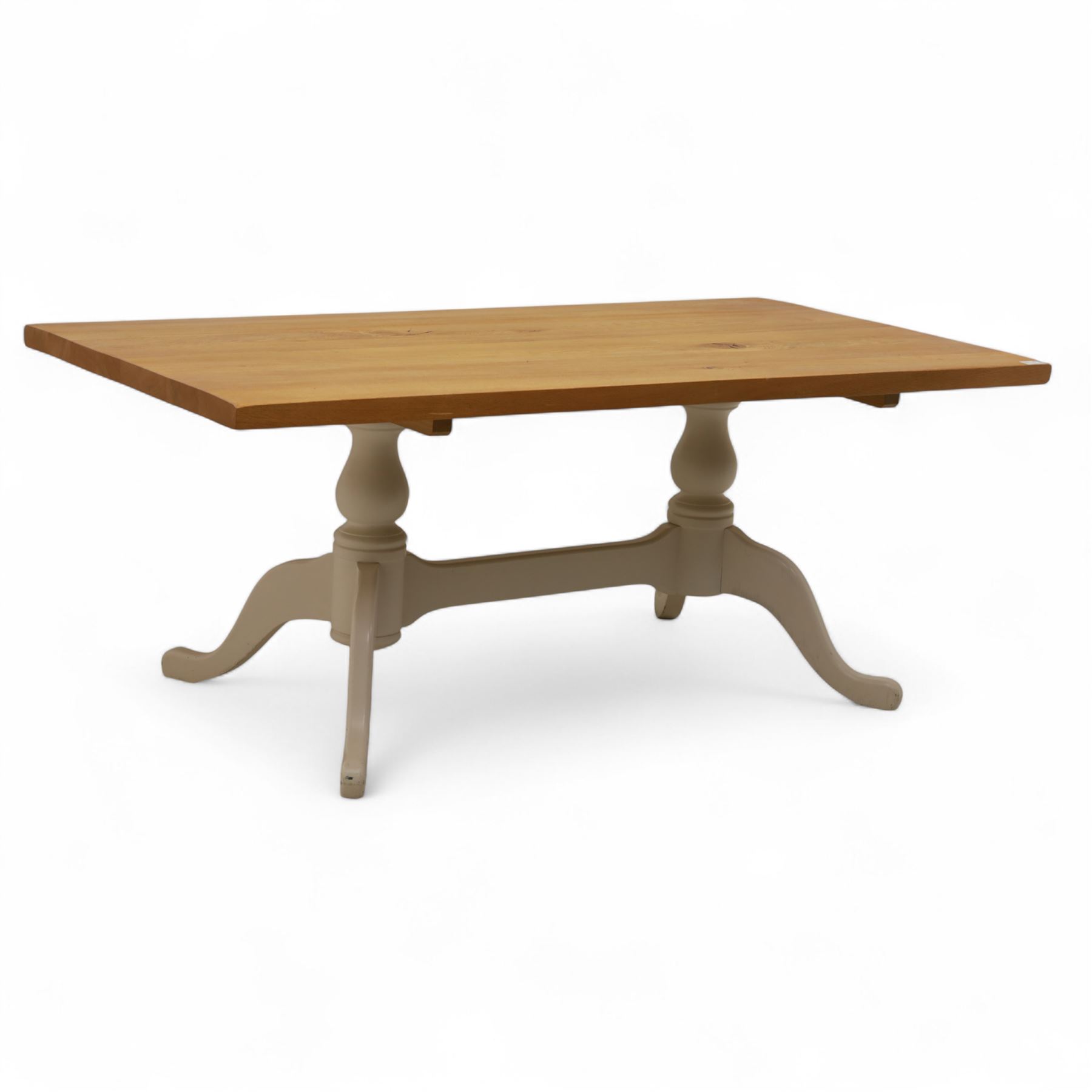 Contemporary light oak dining table, painted tripod bases with stretcher 
