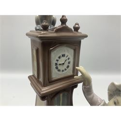 Lladro figure, Bedtime, modelled as a young girl reaching for her pet cat upon grandfather clock, sculpted by Vincente Martinez, with original box, no 5347, year issued 1986, year retired 1998, H28cm
