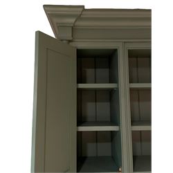 Large contemporary teal green painted kitchen dresser, projecting cornice over three open shelves flanked by cupboard with five spice drawers below, the base fitted with four assorted drawers, raised on turned vasiform supports united by undertier