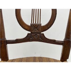 19th century elm elbow chair, shaped and moulded cresting rail over lyre back carved with flower heads, rush seat, on turned supports joined by stretchers