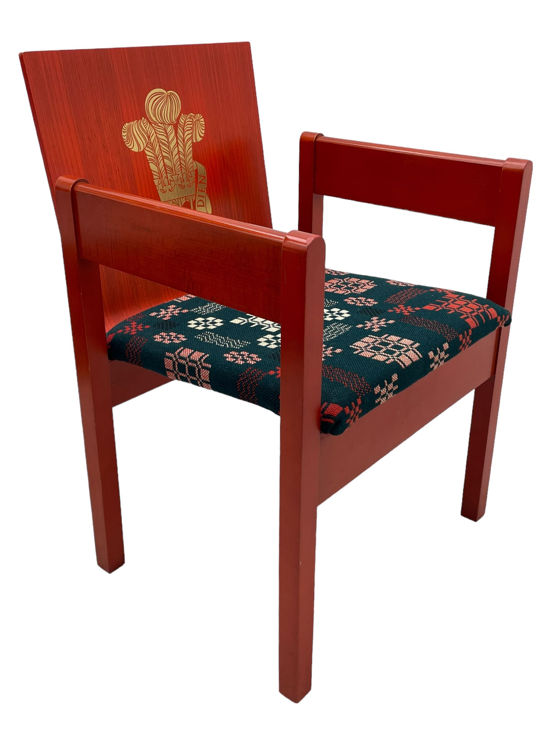 Prince Charles Investiture Chair - designed by Lord Snowdon, manufactured by Remploy, 1969, red finish and decorated with the Prince of Wales's feathers and moto 'Ich Dien' in gilt, later upholstered seat in 1950s design Welsh blanket weave fabric 