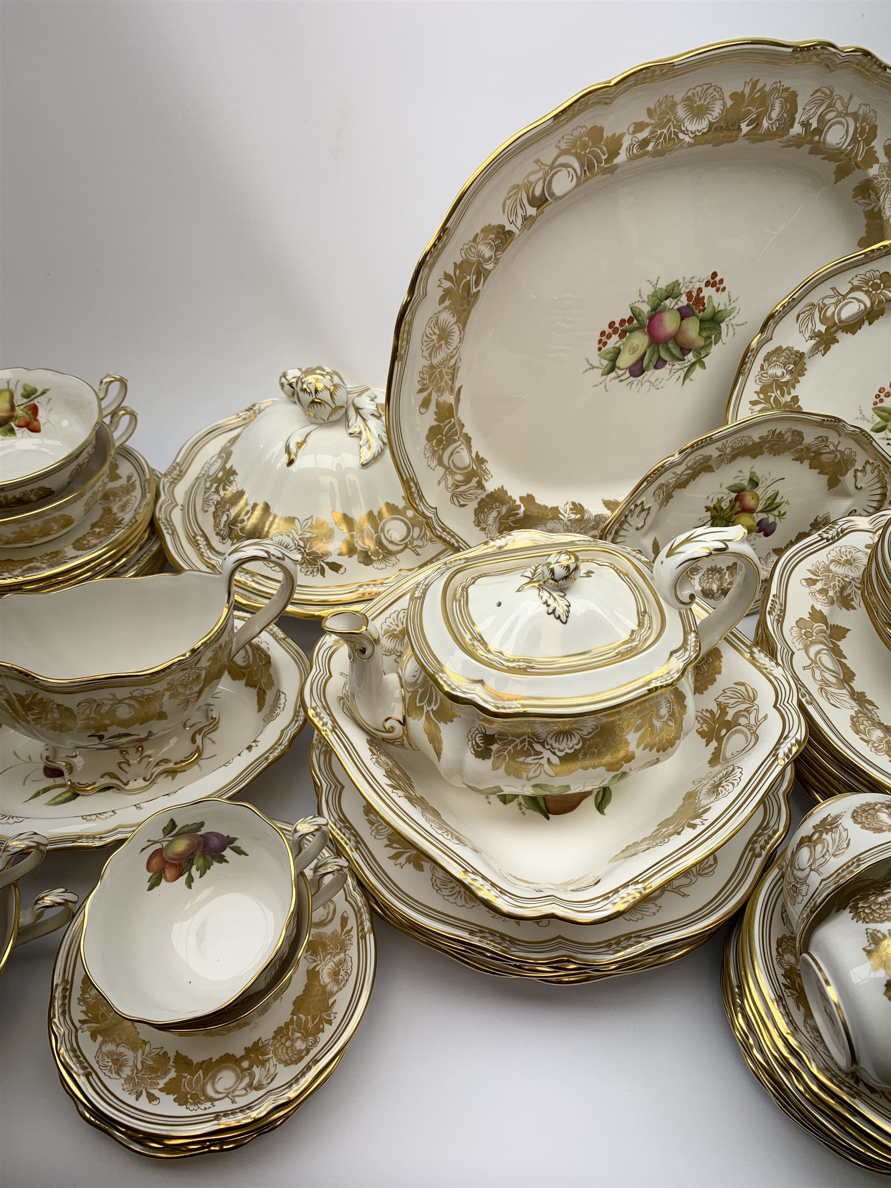 Extensive Spode dinner and tea service, decorated in the Golden Valley pattern, comprising eighteen dinner plates, ten salad plates, ten side plates, ten twin handled soup bowls and ten saucers, ten bowls, two sauce boats and two stands, two square serving dishes, smaller oval serving dish, two tureens and covers, two large oval serving platters, one smaller example, teapot, coffee pot, milk jug, twin handled lidded sucrier, and ten teacups and ten saucers, with red printed marks beneath 