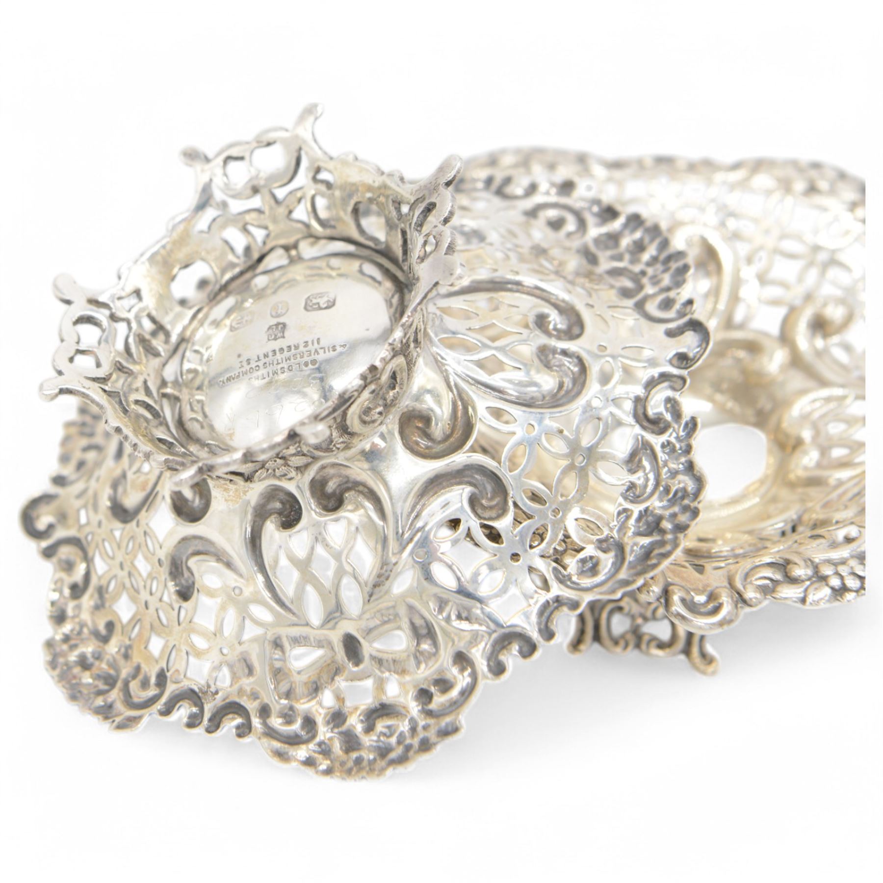 Pair of late Victorian silver bon bon dishes, of hexagonal form with embossed and pierced scrolling decoration, upon a circular pierced base, hallmarked Goldsmiths & Silversmiths Co, Birmingham 1893, W11cm, H4cm