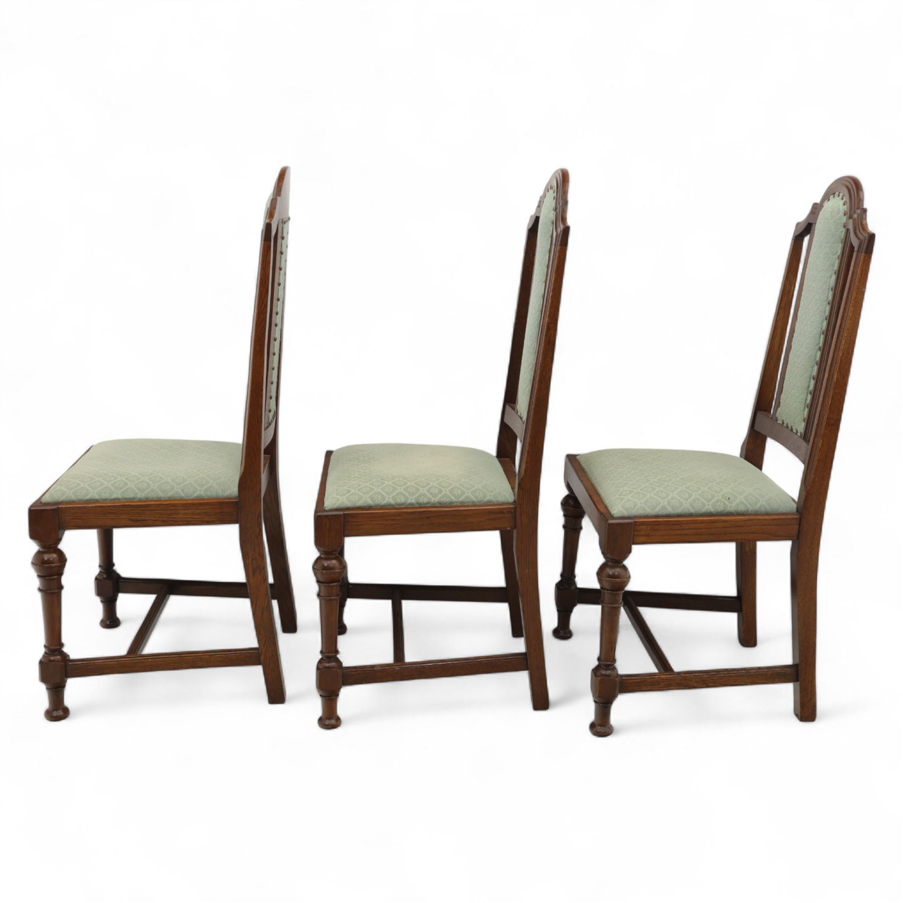 Victorian mahogany extending dining table, rectangular top with chamfered corners above a plain frieze raised on turned reeded legs with castors and two additional leaves, 197cm fully extended, and a set of six early 20th century oak upholstered chairs with drop-in seats, arched panelled back splat and close studded border on turned front legs joined by stretchers, 47x41x109cm 