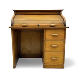 Leeway - late 19th century light oak child's roll-top desk, tambour top opening to reveal fitted interior with green felt writing surface and five pigeonholes, over three graduated drawers on the right side, raised on panelled side supports