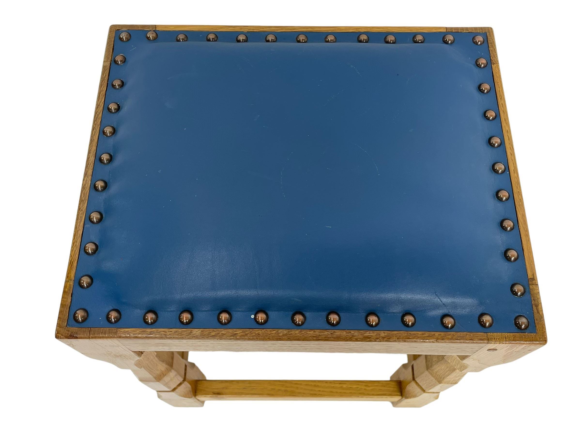 Brian Haw (former Mouseman carver) - Yorkshire oak stool, blue leather upholstered seat with stud band, on octagonal supports joined by plain stretchers