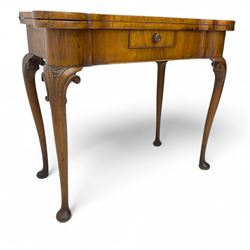 Georgian walnut fold-over card table, shaped rectangular top opening to reveal a baize-lined surface, supported by a concertina pull-out rear mechanism, frieze fitted with single drawer, raised on cabriole supports with foliate carvings terminating in pad feet