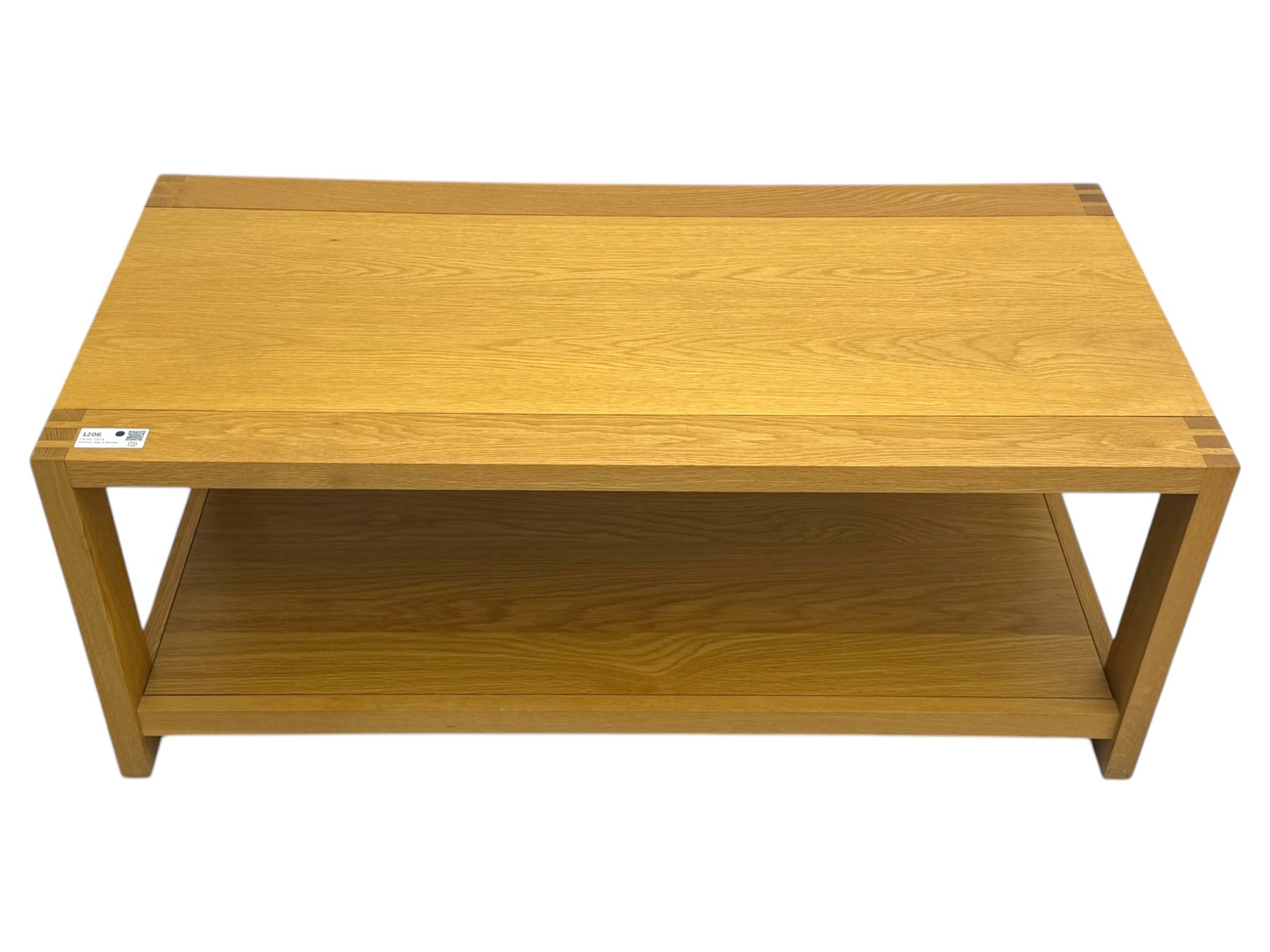 Light oak rectangular coffee table, with exposed finger joints to the corners, raised above a full-length undertier on straight supports