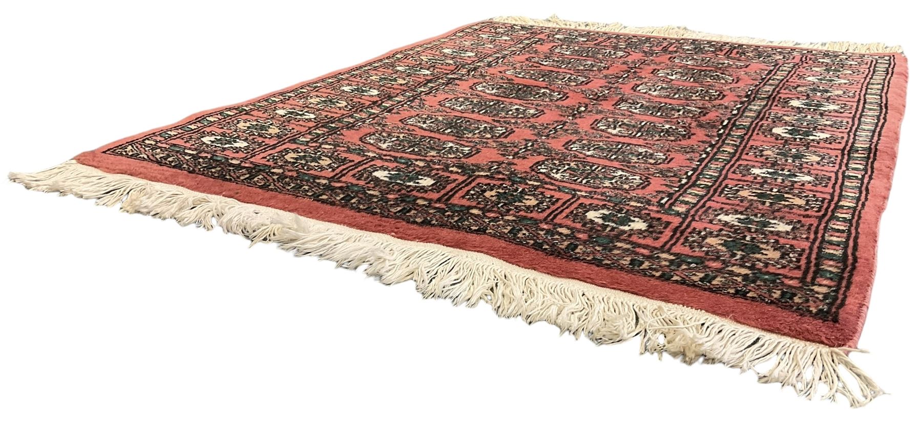 Small peach ground Bokhara rug, decorated with two rows of Gul motifs 