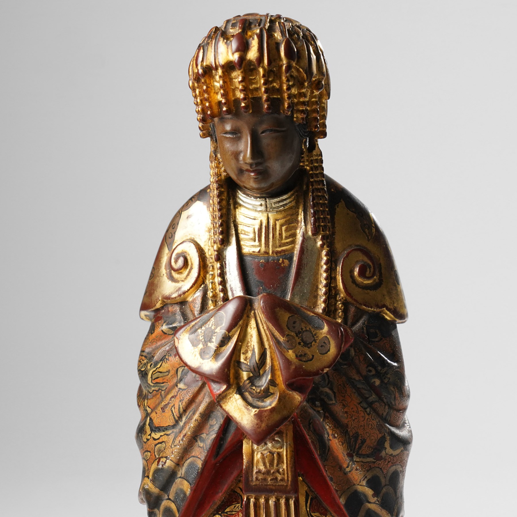 Pair of Chinese carved wooden lacquered figures, in ceremonial dress, possibly wedding attire, highlighted throughout in gilt, H22cm