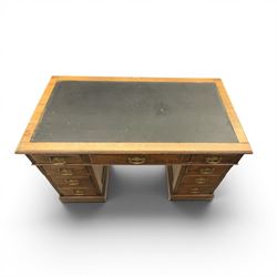 Oak twin pedestal desk with leather top, moulded rectangular top with inset black leather writing surface, nine fielded panelled drawers with brass handles, raised on a plinth base with castors