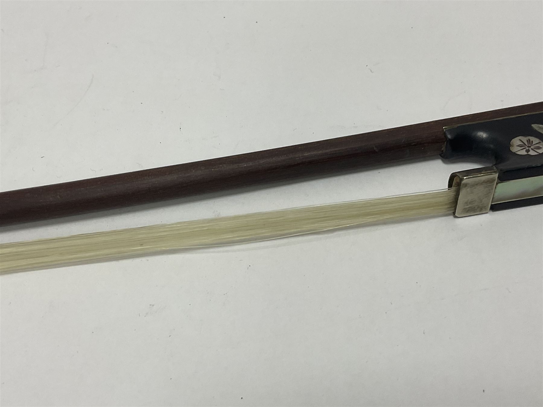 19th century wooden violin bow with a decorative mother of pearl inlay depicting flowers to the frog, with a bone adjuster screw