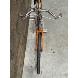 Fully restored vintage advertising bicycle with 2 stroke petrol engine, orange frame, tan leather seat