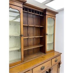 Late Victorian oak dresser, reverse break front top with projecting cornice, three central shelves flanked by glazed display cabinets, the base fitted with three drawers, two cupboards and shelves
