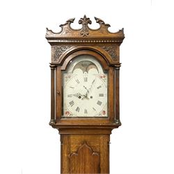 George Clapham of Brigg - Late 18th century 8-day oak cased longcase clock c1790 - flat topped hood with later carved addition, dog tooth moulding and blind fretwork beneath, break arch hood door flanked by reeded pilasters and capitals, trunk with canted corners and  door with a triple arched top, plinth with a later base with decoratively shaped feet, early painted dial with flowers enclosed in a gesso border to the spandrels, rolling moon to the arch, seconds dial and calendar aperture, Roman numerals and five minute Arabic's with makers name (indistinct), dial pinned via a false plate to a rack striking movement. With weights, key and pendulum.
