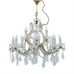 20th century Maria Theresa style twelve branch chandelier, gilt metal frame with scrolling arms clad in moulded glass, the central baluster stem issuing twelve candle sconces with glass drip pans, hung with faceted pendants and swags of cut glass beads 