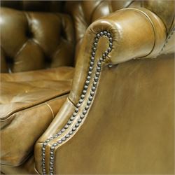 20th century George II style leather upholstered hall porters chair, brass studded upholstered with piping in leather on all sides, the inside top back arms and seat are all pleated and deep buttoned, with removable seat pad, on castors