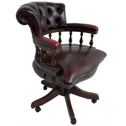 Georgian design swivel desk chair, the rolled back over balustrade support, upholstered in buttoned oxblood leather with studwork border, over a swivel and reclining action with splayed supports and castors