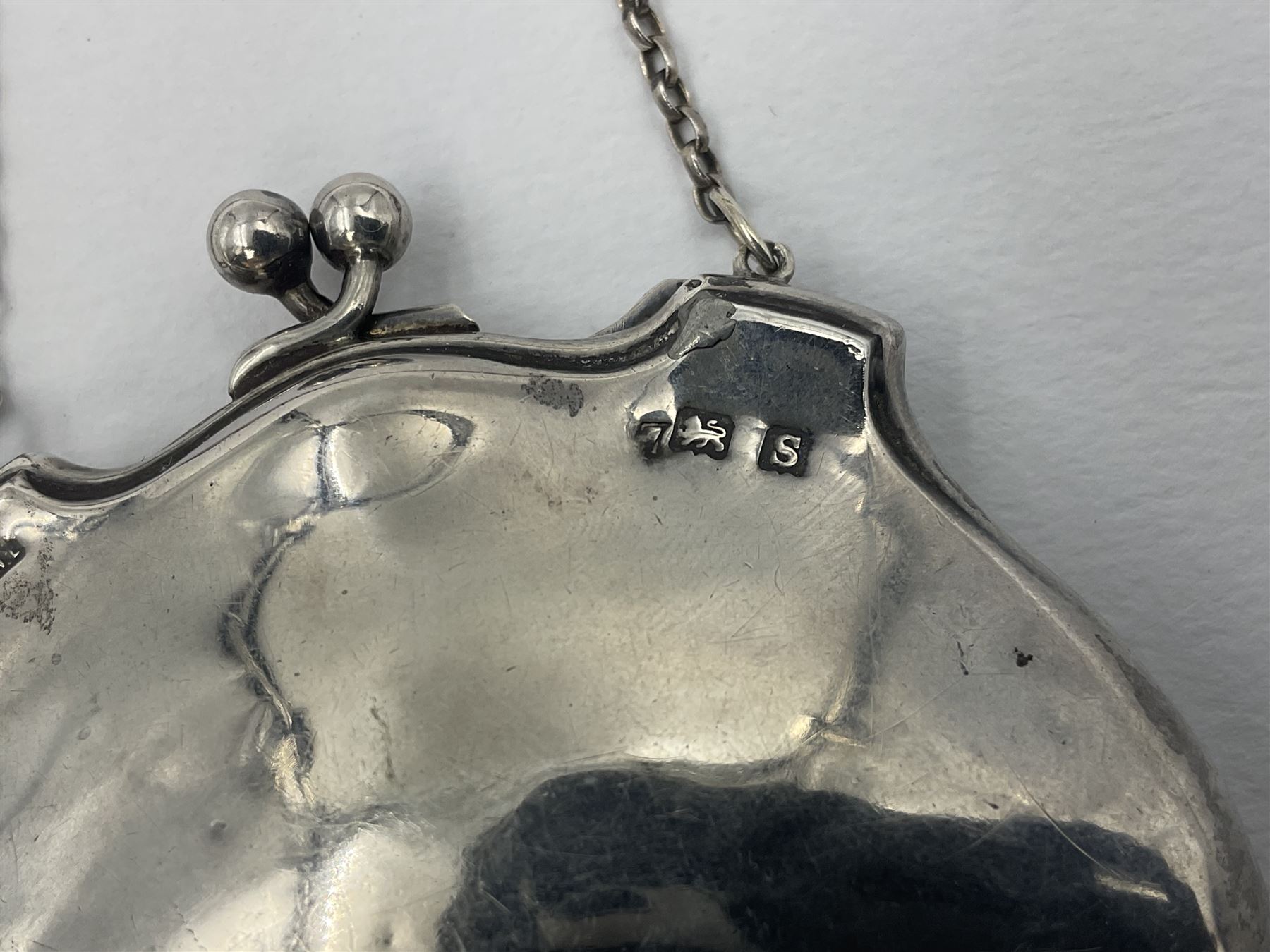 Early 20th century silver mounted coin purse, with leather interior and finger chain, hallmarked Samuel M Levi, Birmingham 1917, together with a similar Edwardian example, with engraved initials and engine turned decoration, hallmarked Birmingham 1907, maker's mark worn and indistinct, largest W11.3cm