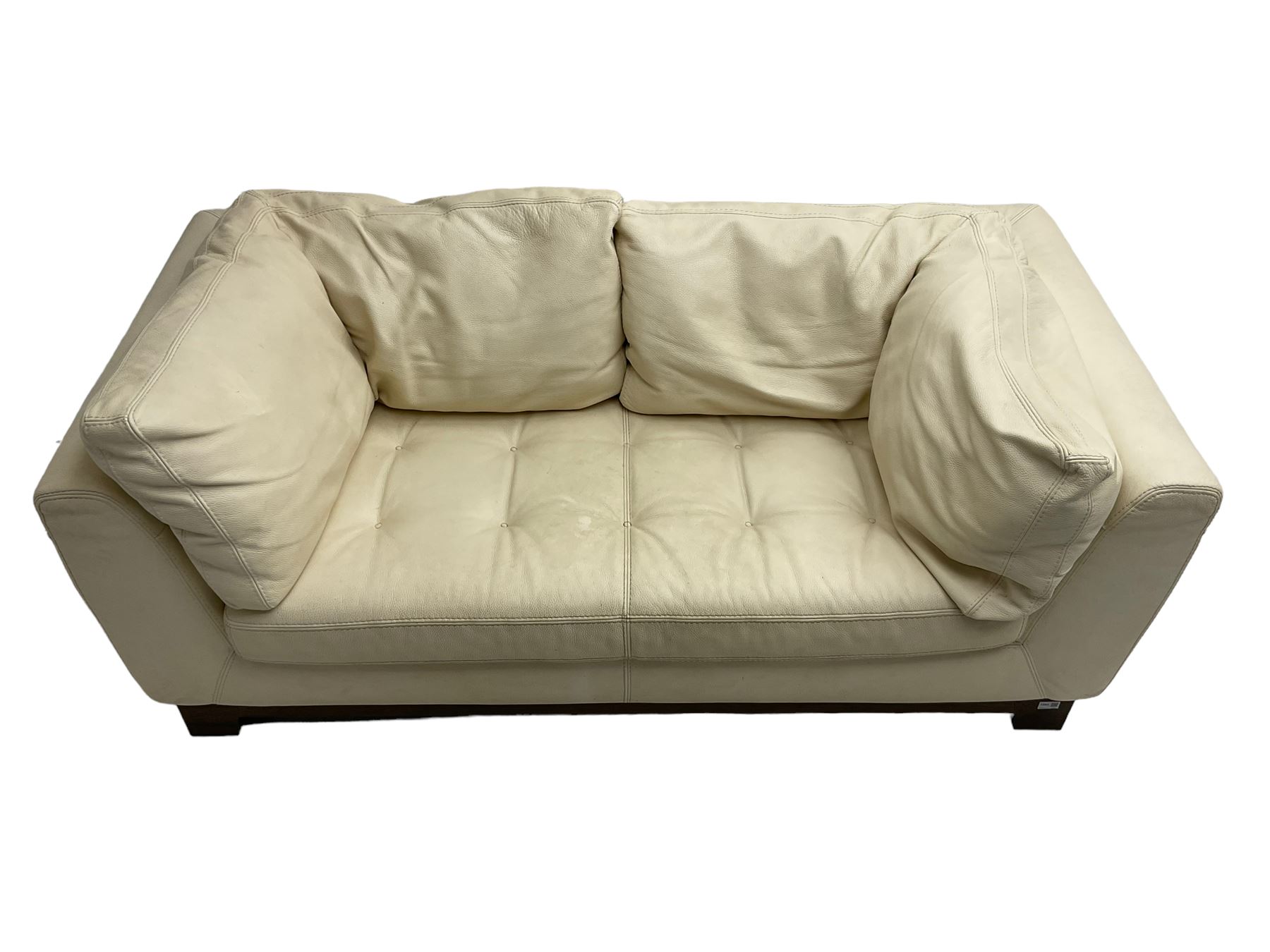 Roche-Bobois - two seat sofa, upholstered in ivory leather with buttoned seat cushions, raised on a stained beech base with bracket feet