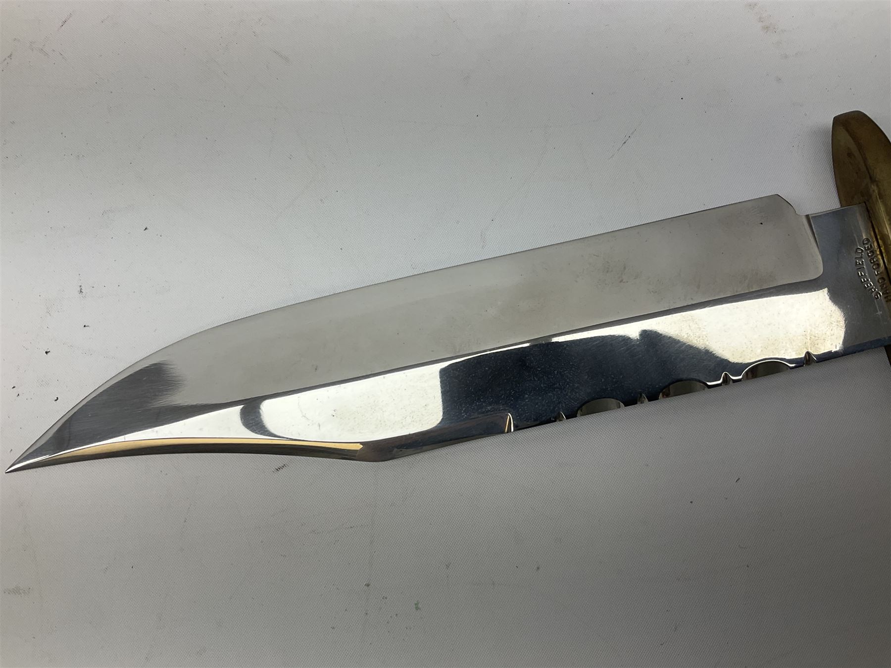 Large Bowie knife the 21cm steel blade marked J.E. Middleton & Sons Rockingham Street Sheffield with brass cross-piece and polished horn grip scales; in leather sheath L36cm overall