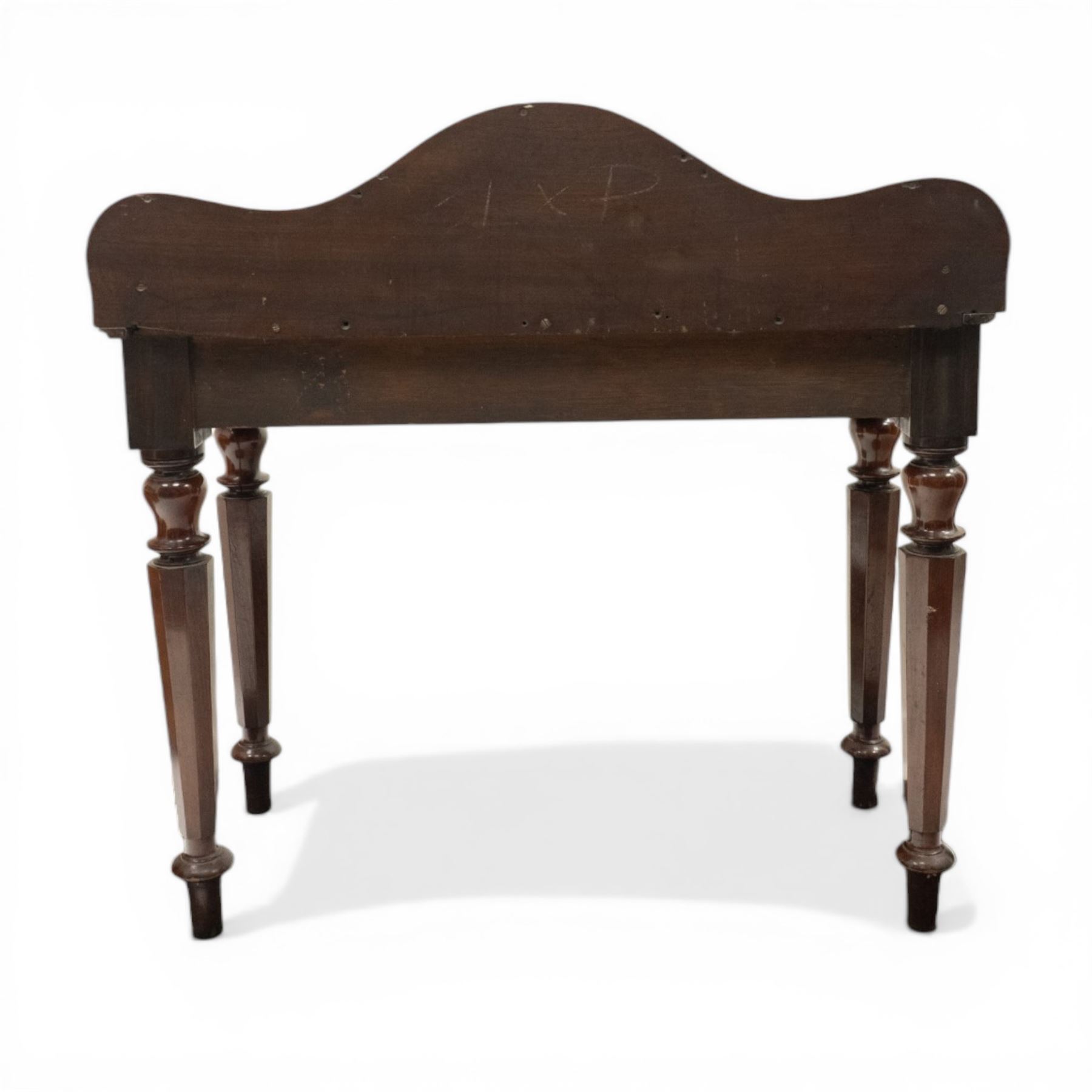 Victorian mahogany side table, raised back with scroll-moulded edge over a rectangular top, raised on turned octagonal supports