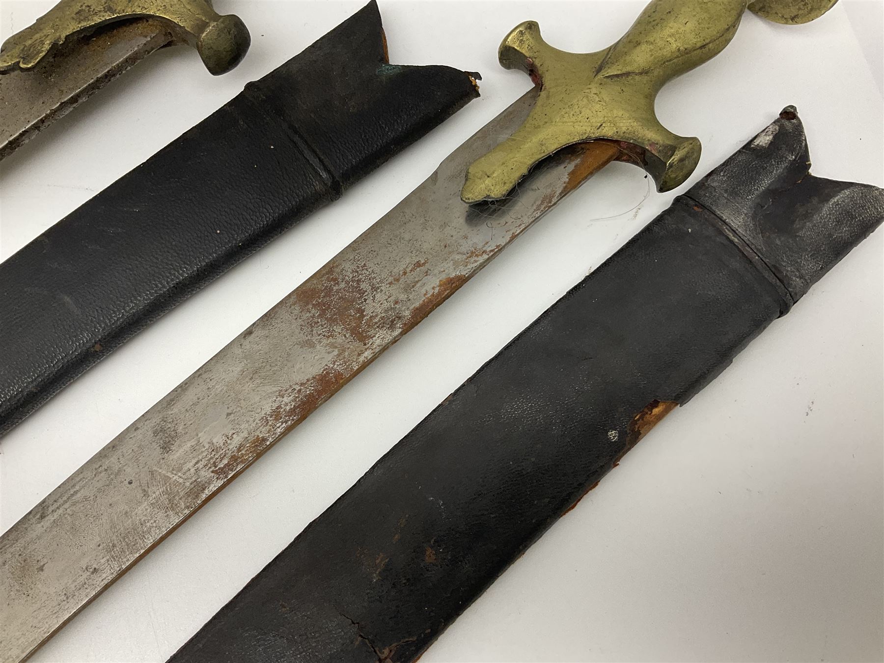 Four Indian tulwar swords; three with cast brass hilts and one with iron hilt; longest blade 81cm; all with scabbards (4)