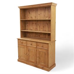 Late 20th century pine kitchen dresser, the upper section with open shelves and tongue and groove back, over a triple cupboard base with three drawers, turned wooden knobs throughout
