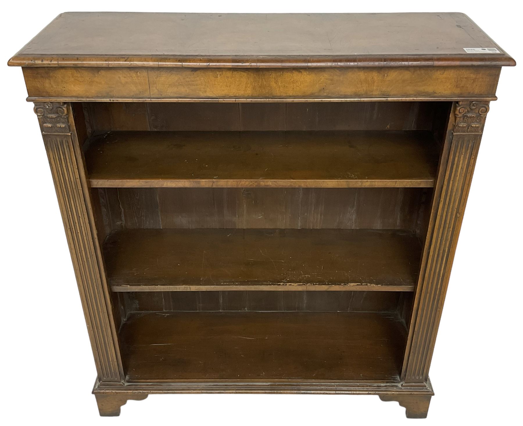 Georgian design walnut open bookcase, fluted uprights with acanthus carved capitals enclosing two adjustable shelves, on bracket feet
