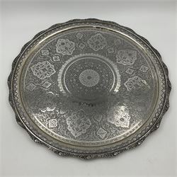 Early/mid 20th century Persian silver tea service, comprising circular serving tray, teapot, twin handled sucrier and cover, milk jug, five tea glasses with six silver holders, six tea spoons, and pair of sugar tongs, each profusely chased with foliate arabesque decoration, each bearing marks including 84 for 840 fineness, tray D40cm, teapot H16cm