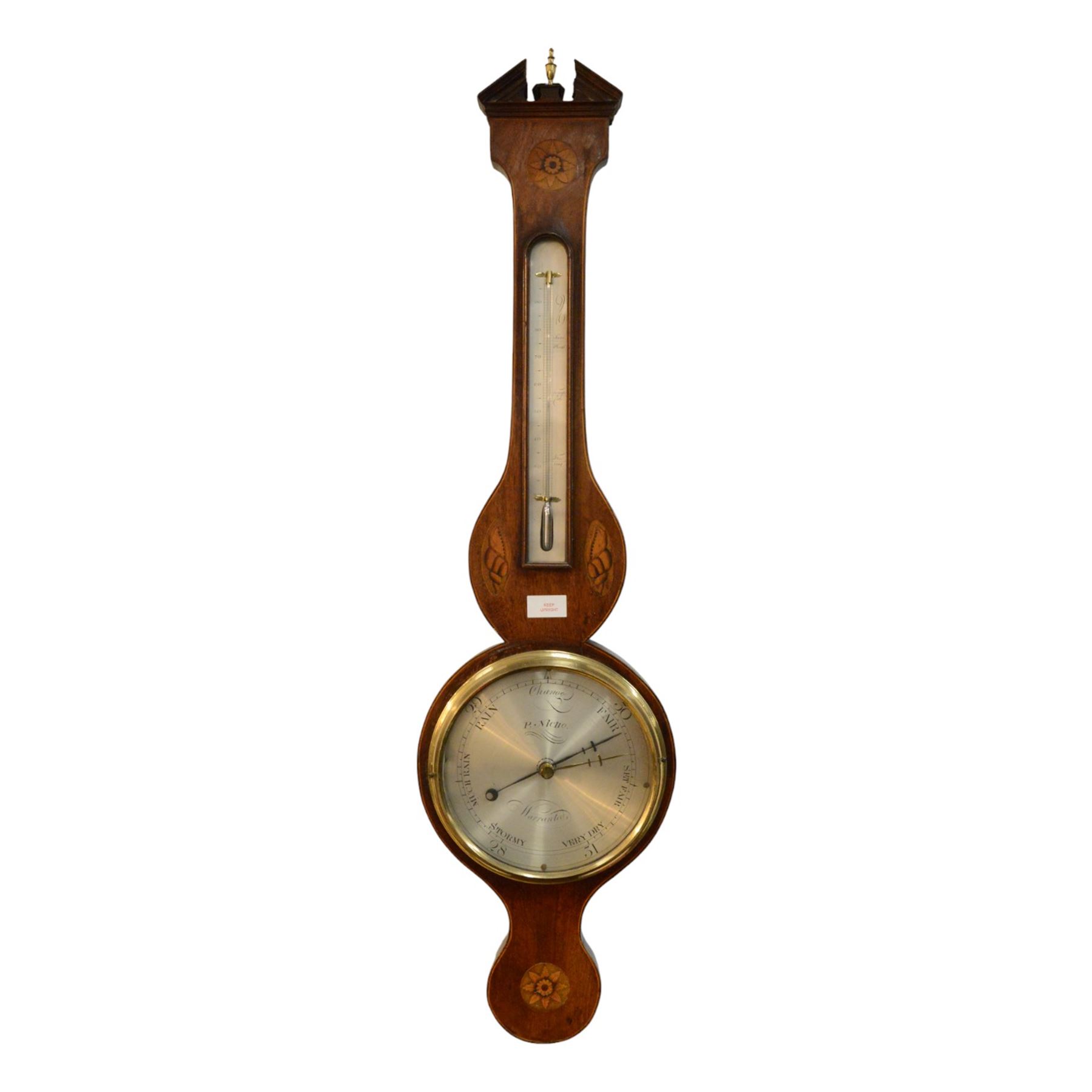 Early 19th century-Sheraton two instrument mercury barometer c1820, with a break arch top and round base, mahogany veneer with inlaid motifs and stringing to the edge, surface mounted mercury thermometer recording degrees Fahrenheit and an 8” silvered register with predictions and recording barometric air pressure from 28 to 31 inches, with a steel indicating hand and brass recording hand. Dial inscribed P. Nicho. 
Mercury present, syphon tube and pulleys intact.