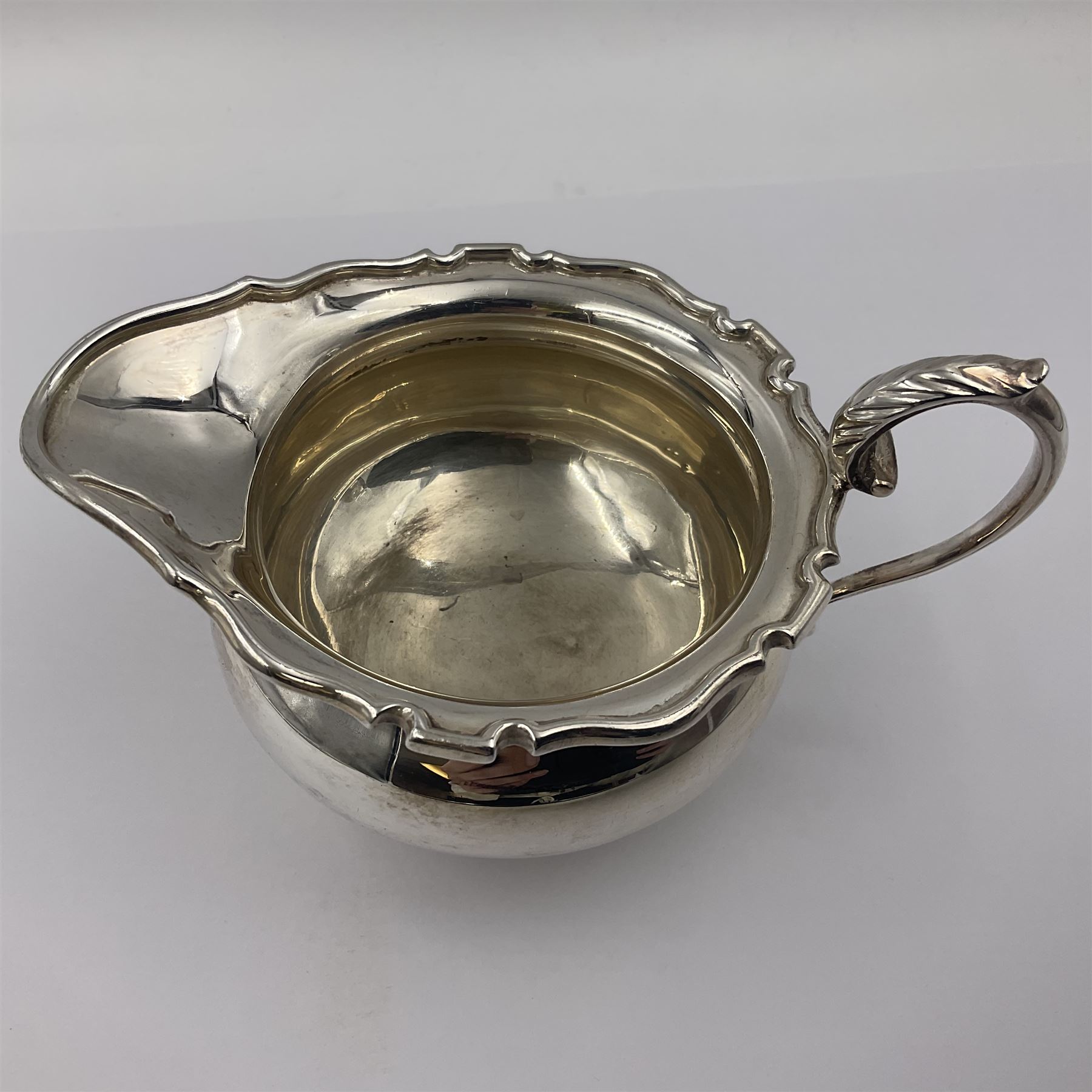 1920s five-piece silver tea service, comprising teapot, coffee pot, hot water pot, twin handled open sucrier and milk jug, each of squat circular form with shaped rim, the teapot, coffee pot and hot water pot each with ebonised handle and finial, the sucrier and milk jug with acanthus capped scroll handles, all upon circular foot, hallmarked R F Mosley & Co, Sheffield 1926 & 1927, tallest H24cm