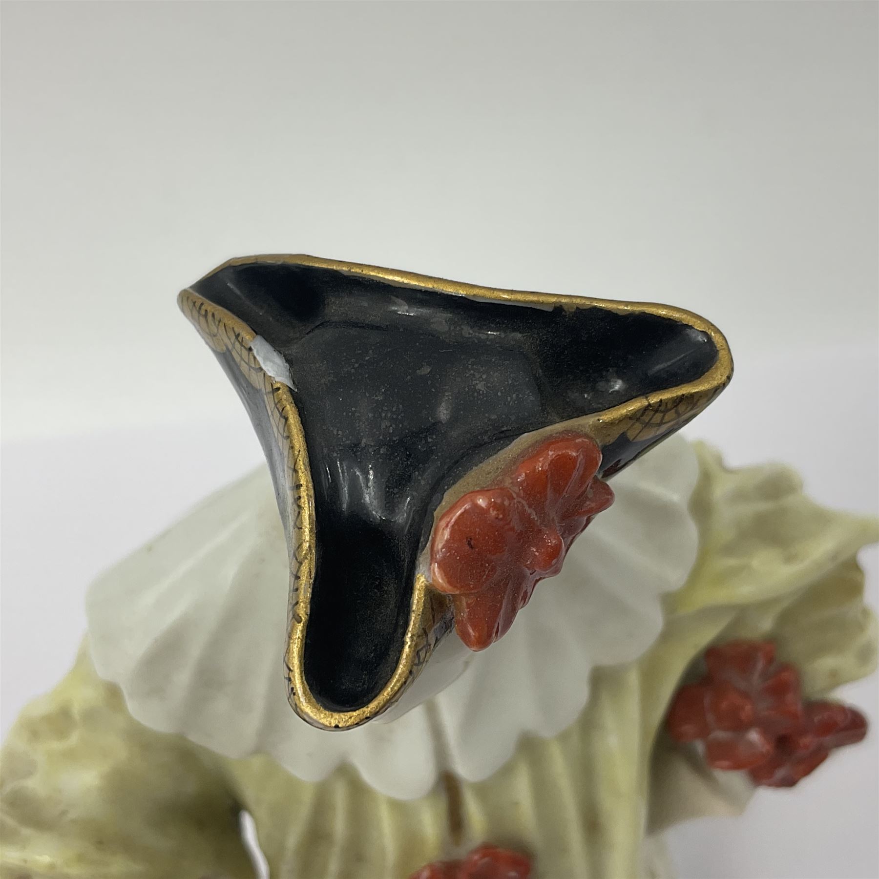 18th century Meissen figure of a Avvocato or the Lawyer from the Commedia Dell'arte series, circa 1740-45, modelled by J J Kandler, wearing gilt edged black tricorn hat, white mask, and yellow cape adorned with red rosettes, holding a scroll in his right hand, upon shaped oval base, no visible mark, H14.5cm