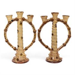 Pair of studio pottery candlesticks, with a central twisted column bordered by circular supports, H24cm 