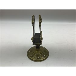 Collection of victorian and later brass desk accessories, to include a letter holder with cherub design, ink well of square form with hinged lid, brass table bell, brass casket with relief decoration, etc  