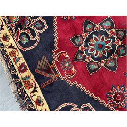 Persian rug, red ground field decorated with stylised flower heads and bird motifs, floral scrolling border