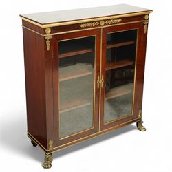 19th-century French Empire-style mahogany and gilt bronze-mounted glazed cabinet, rectangular top above frieze with applied gilt bronze laurel swags and rosettes with gilt brass borders, over two glazed panel doors enclosing three adjustable shelves, flanked by plain pilasters with applied mounts, raised on gilt bronze paw feet 