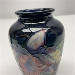 Moorcroft Clematis pattern upon cobalt blue ground miniature globular vase, together with Moorcroft Iris pattern upon a cobalt blue ground miniature vase, largest H9cm
