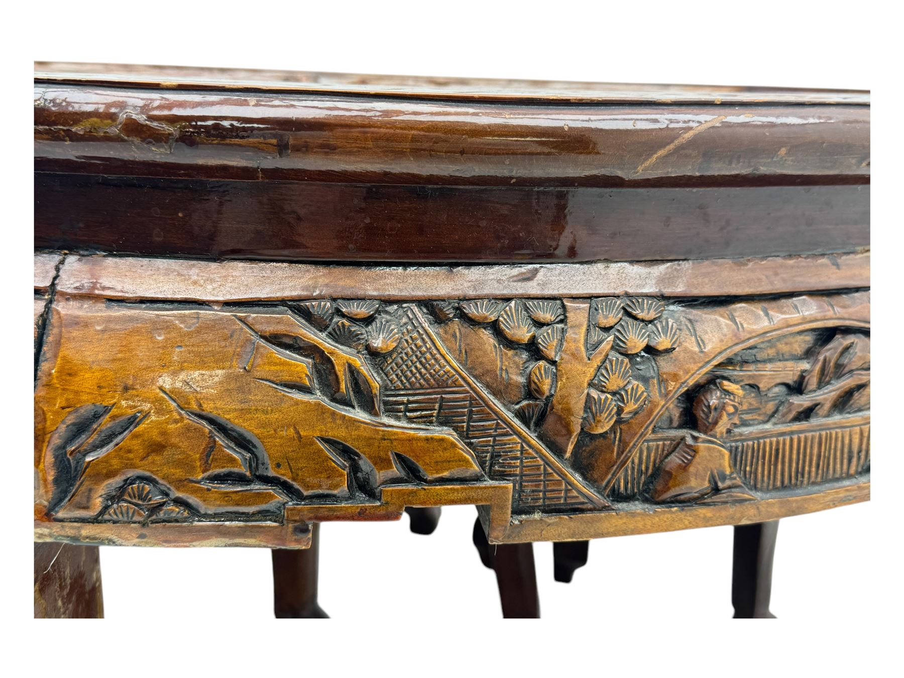 Early 20th century Chinese hardwood nesting coffee table, oval top carved with figures and traditional pagoda scenes with carved frieze, complete with six inset stools or side tables, raised on tapering supports with paw feet