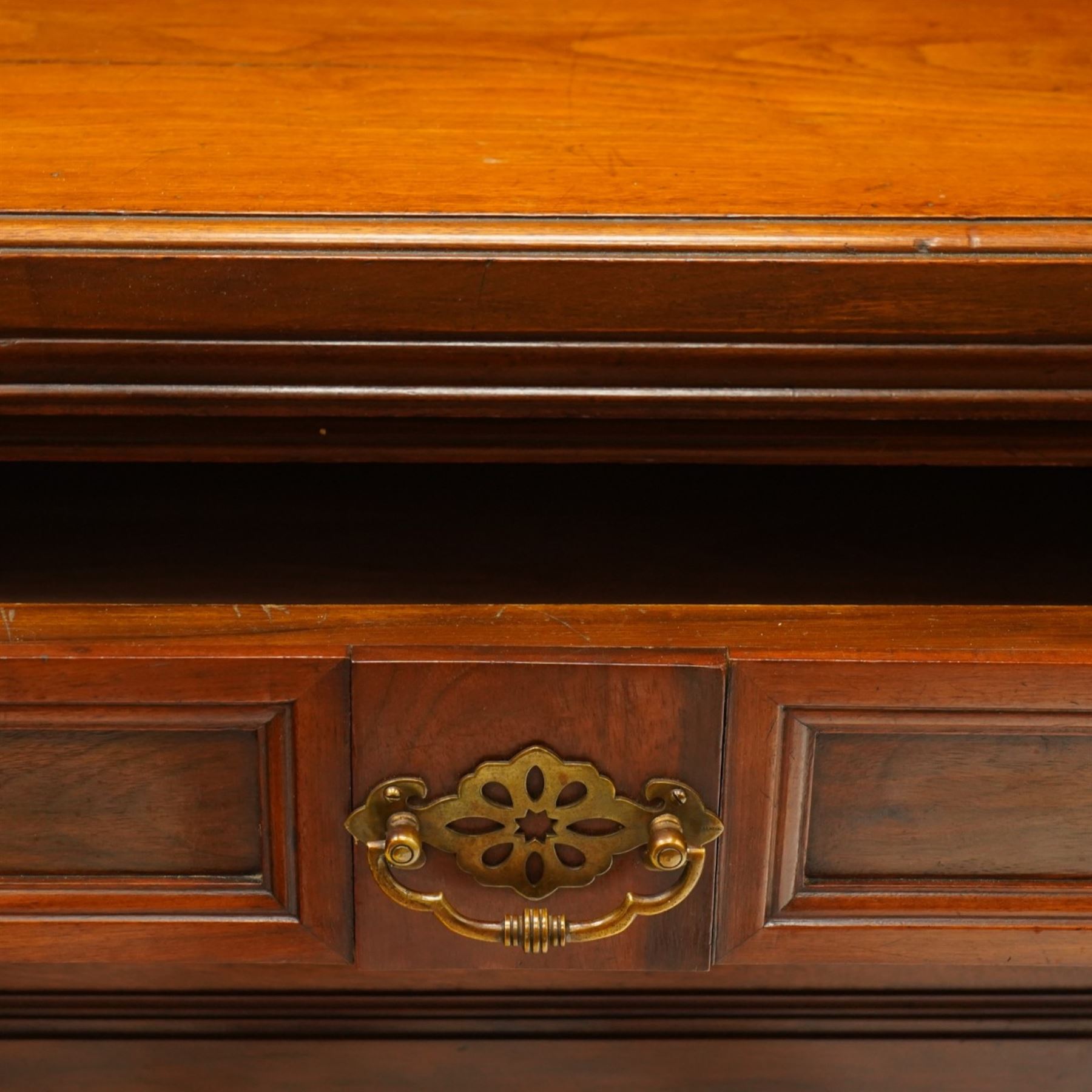 Late Victorian mahogany mirrored back sideboard, the mirror back with three bevelled mirror plates above a single shelf, rectangular moulded top over two frieze drawers with brass handles, above a twin panelled cupboard, carved recessed panels decorated with flowers and foliage, fluted uprights, raised on turned feet