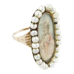 19th century portrait ring, set with an oval miniature of a woman wearing a pink dress on ivory, under a glazed panel, with threaded pearl surround and engraved shoulders. This lot has been registered for sale under Section 10 of the APHA Ivory Act