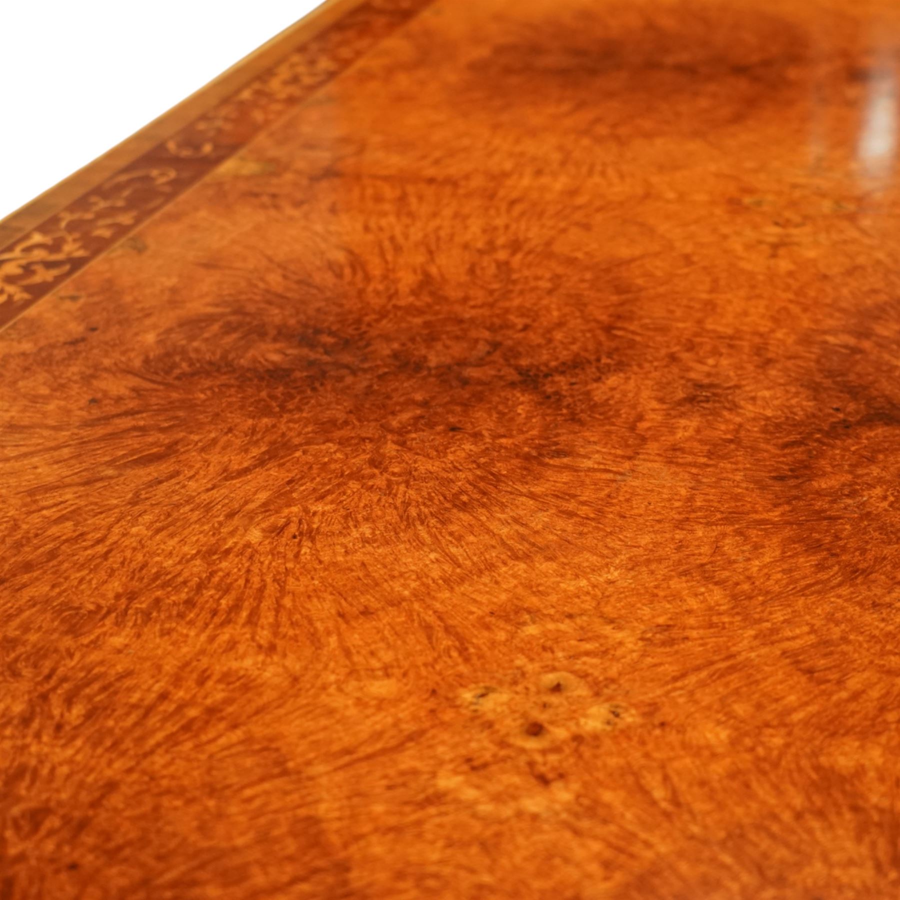 Arthur Brett & Sons - late 20th century twin pedestal dining table in the Second Empire style, the oval Amboyna burl veneered top, bordered with tulipwood crossbanding and delicate floral marquetry inlay, and rosewood crossbanded outer border within gilt gadrooned edge, over two mahogany triform pedestal bases with rosewood crossbanding and decorated with neoclassical marquetry of tied ribbons, leafy sprays, and scrolling acanthus decoration, raised on carved and gilded lion paw terminals on plinth bases, underside with maker's label