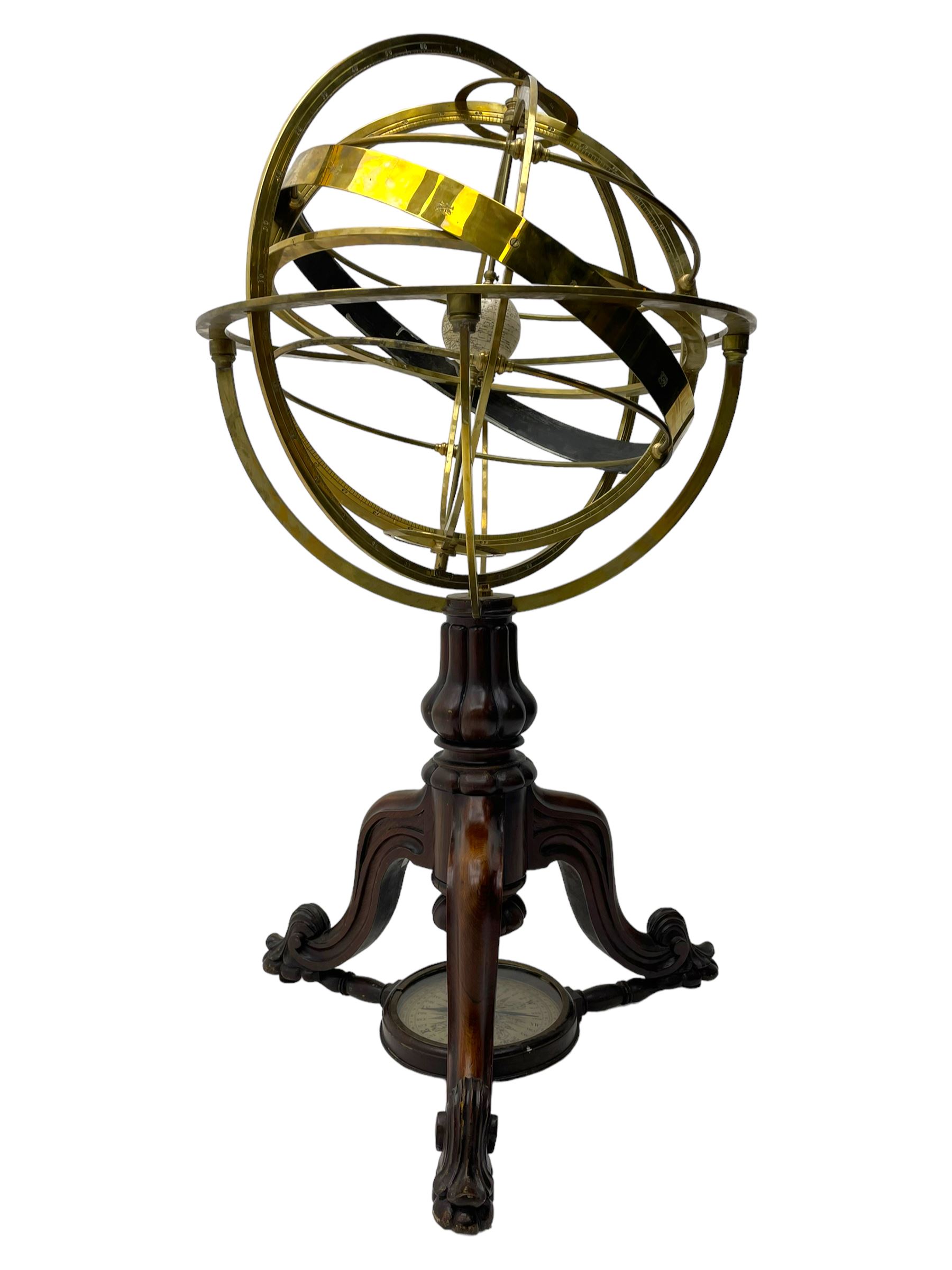19th century brass terrestrial armillary sphere on rosewood base, lobe carved column on three splayed supports with scrolled carved terminals, the supports united by circular compass with turned stretchers