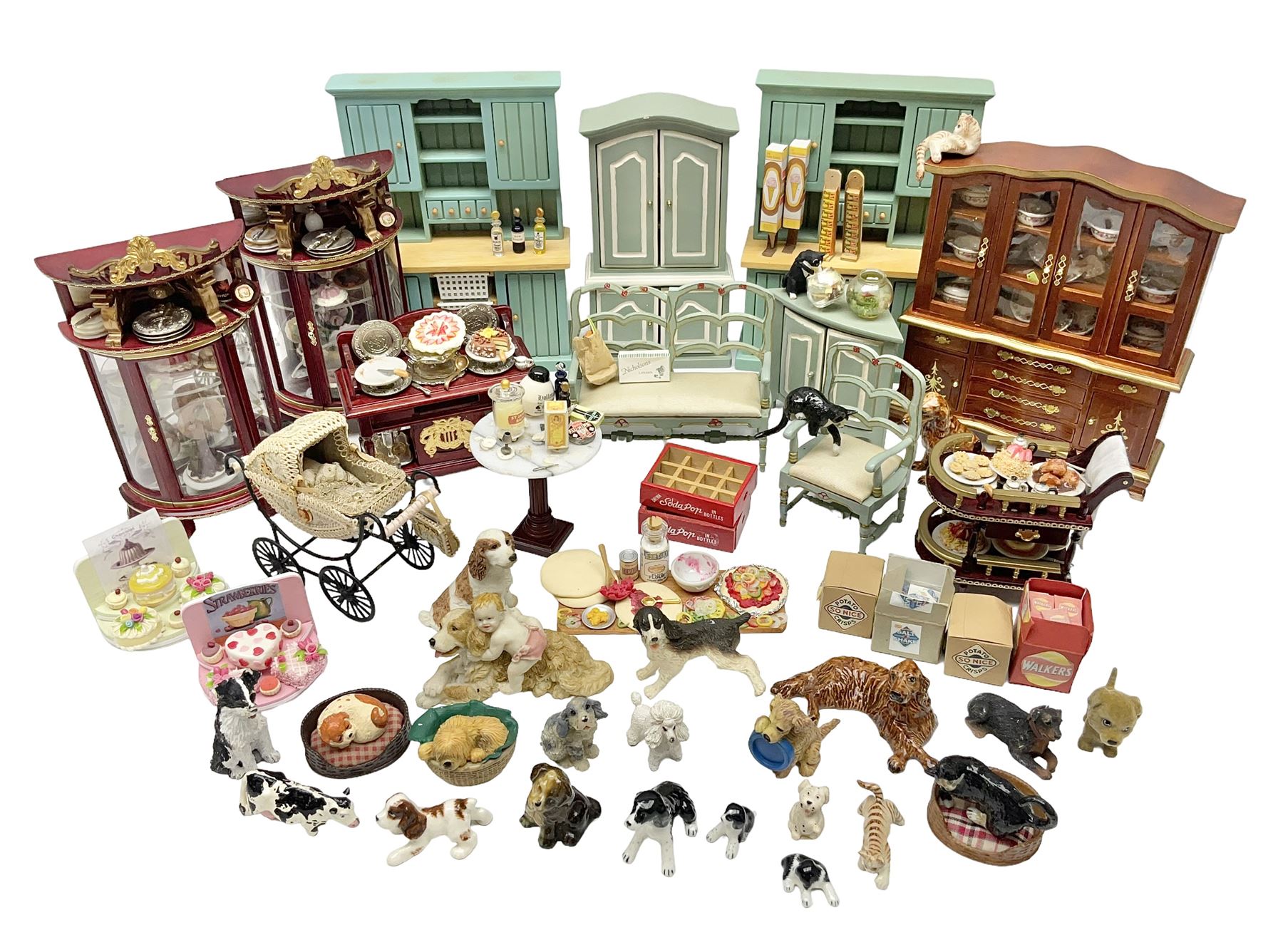 Collection of miniature dolls house furniture, to include display cabinet with pink and white floral dinner service, two serving trolleys with cakes and sweets and two blue painted kitchen dressers, together with miniature dolls house cardboard food packaging and animal figures including dogs and cats, etc