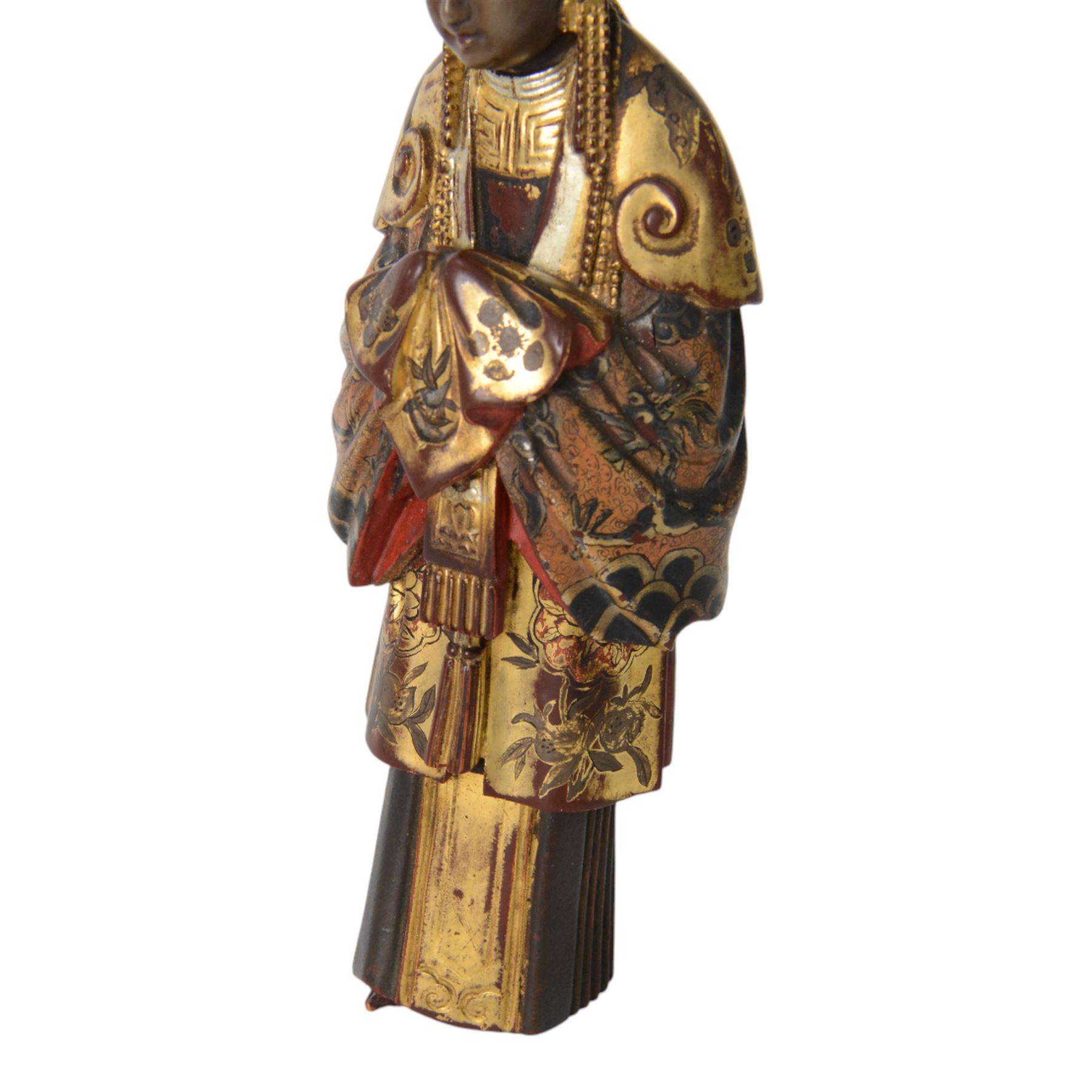 Pair of Asian carved wooden lacquered figures, in ceremonial dress, possibly wedding attire, highlighted throughout in gilt, H22cm