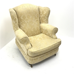 Licoln House wing back armchair, upholstered in a pale gold chenille fabric with floral pattern, shaped back, scrolled arms on turned supports, W91cm