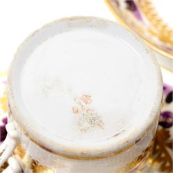 Early 19th century Derby tea and coffee service painted with a border pattern of purple and gilt leaves and flowers comprising four large cups with five saucers, nine coffee cans with twelve saucers, tea pot and stand, slop bowl, milk jug and two plates, red painted mark.