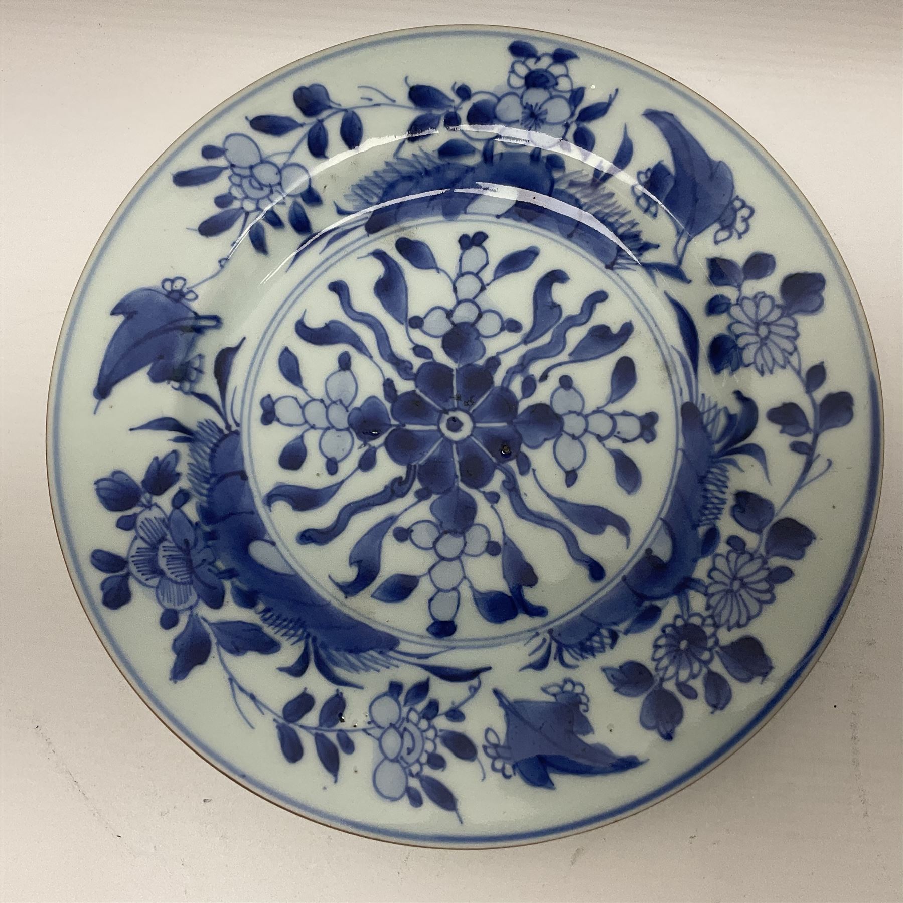 Japanese Meiji period Arita blue and white plate, of circular form, painted with riverside landscape and bird upon flowering branch, with character mark beneath, D24.5cm, together with two 18th century Chinese blue and white plates, each painted with floral design, each approximately D22.5cm