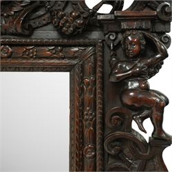Renaissance-style mid 19th century carved fruitwood wall mirror, carved top surmounted by ‘broken’ arched pediment with central putti figure and grape vine, the sides with two putti figures above C-scroll decorations, and with a similarly carved base